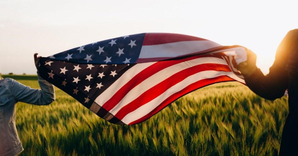 Proud Americans holding the American flag in a field